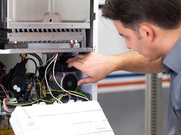 Technician servicing the front of a furnace