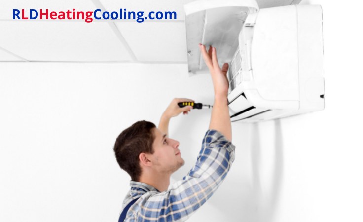Technician installing a wall-mounted air conditioner indoors