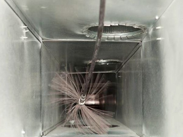 Rotating brush cleaning the inside of a metal air duct