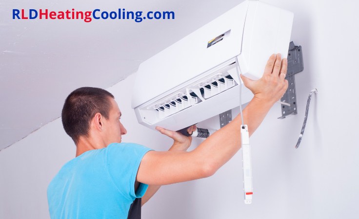 Technician mounting a wall-mounted air conditioner